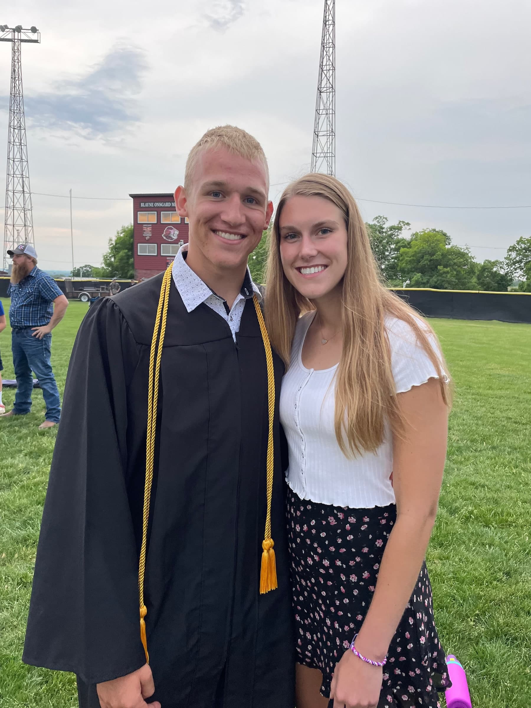 Tysen in his graduation gown beside Alyssa at his 2023 high school graduation