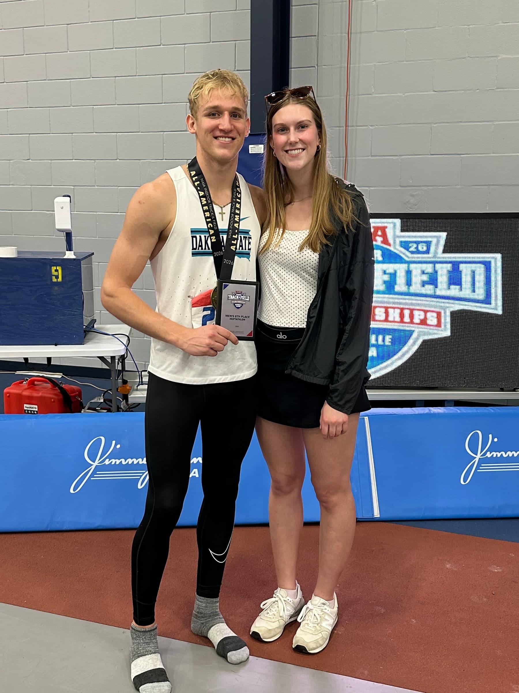Alyssa and Tysen together after his college track meet, Tysen wearing a medal