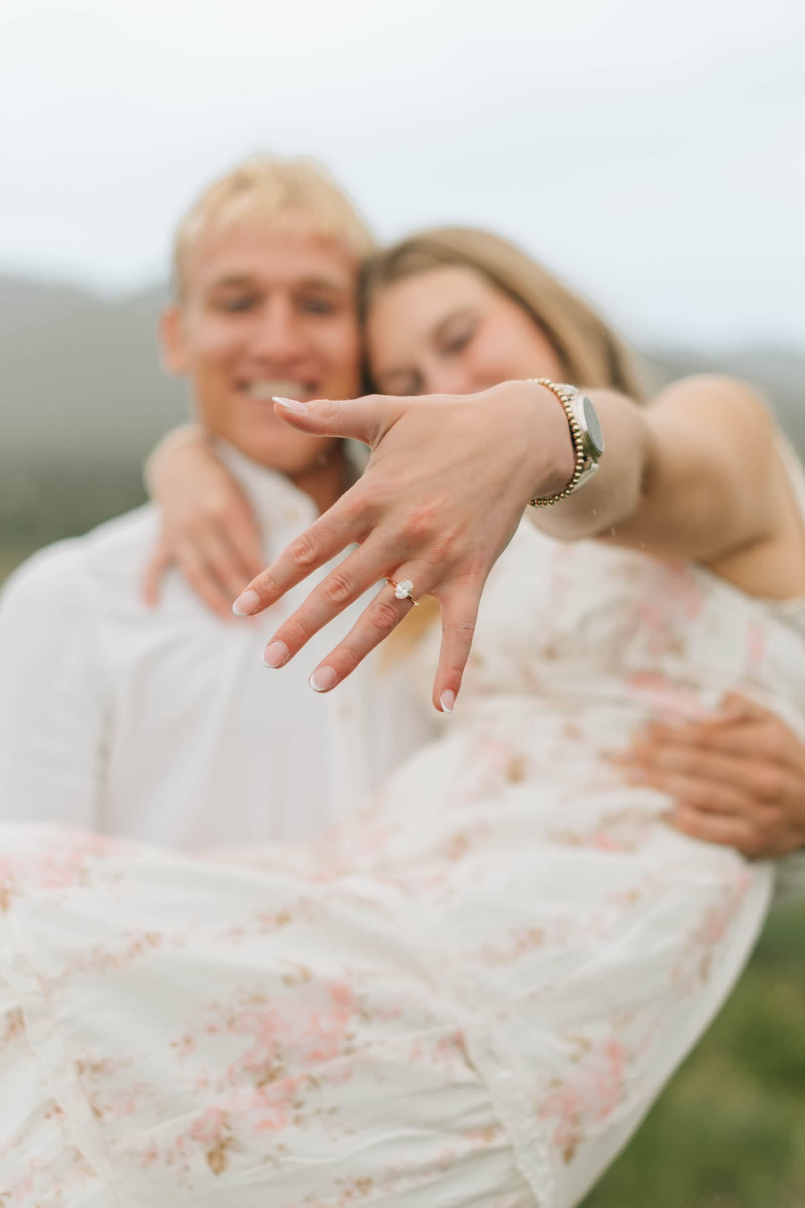 Alyssa holding her engagement ring toward the camera as Tysen kisses her
