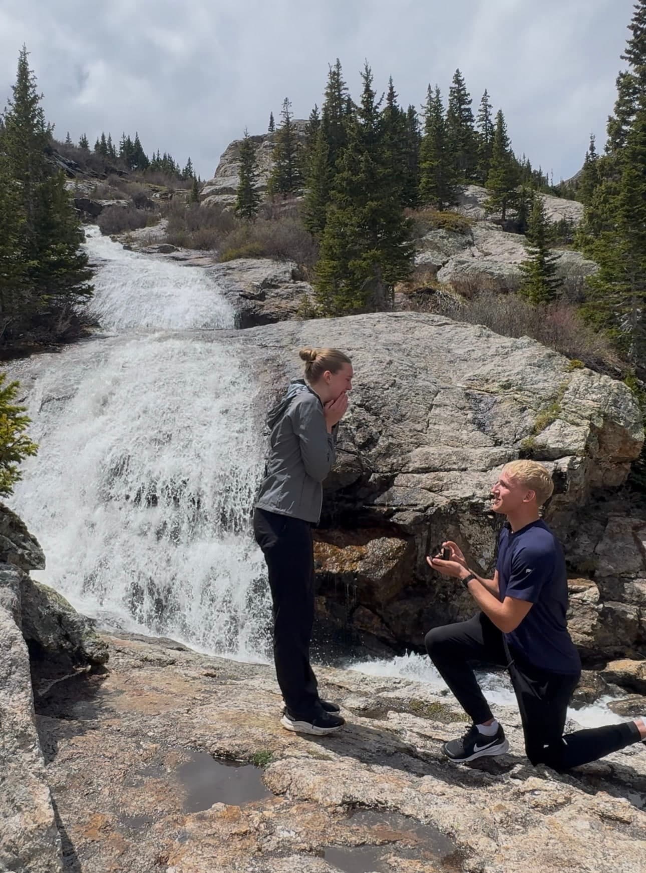 Tysen down on one knee asking Alyssa to marry him beside the waterfall